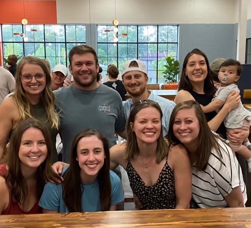 group picture of eight pediatric residents and toddler at indoor event